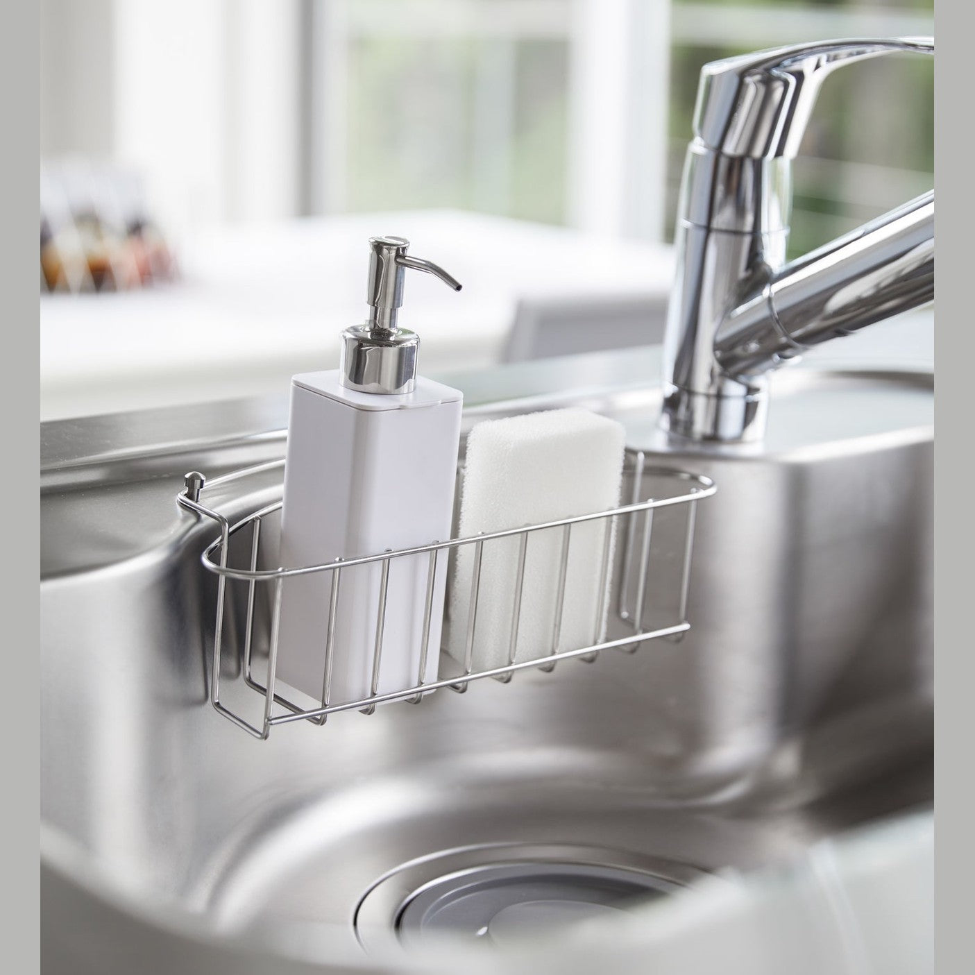 White Hand Soap Dispenser in kitchen sink by Yamazaki Home.