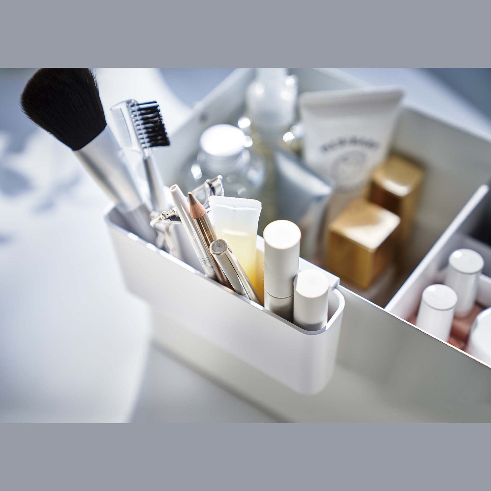 Close up view of white Makeup Organizer attachment holding makeup by Yamazaki Home.