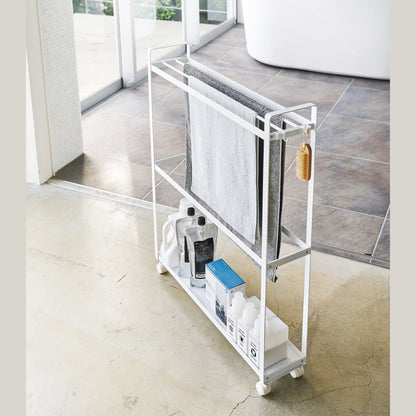 White Rolling Towel Rack holding cleaning products and towels by Yamazaki Home.