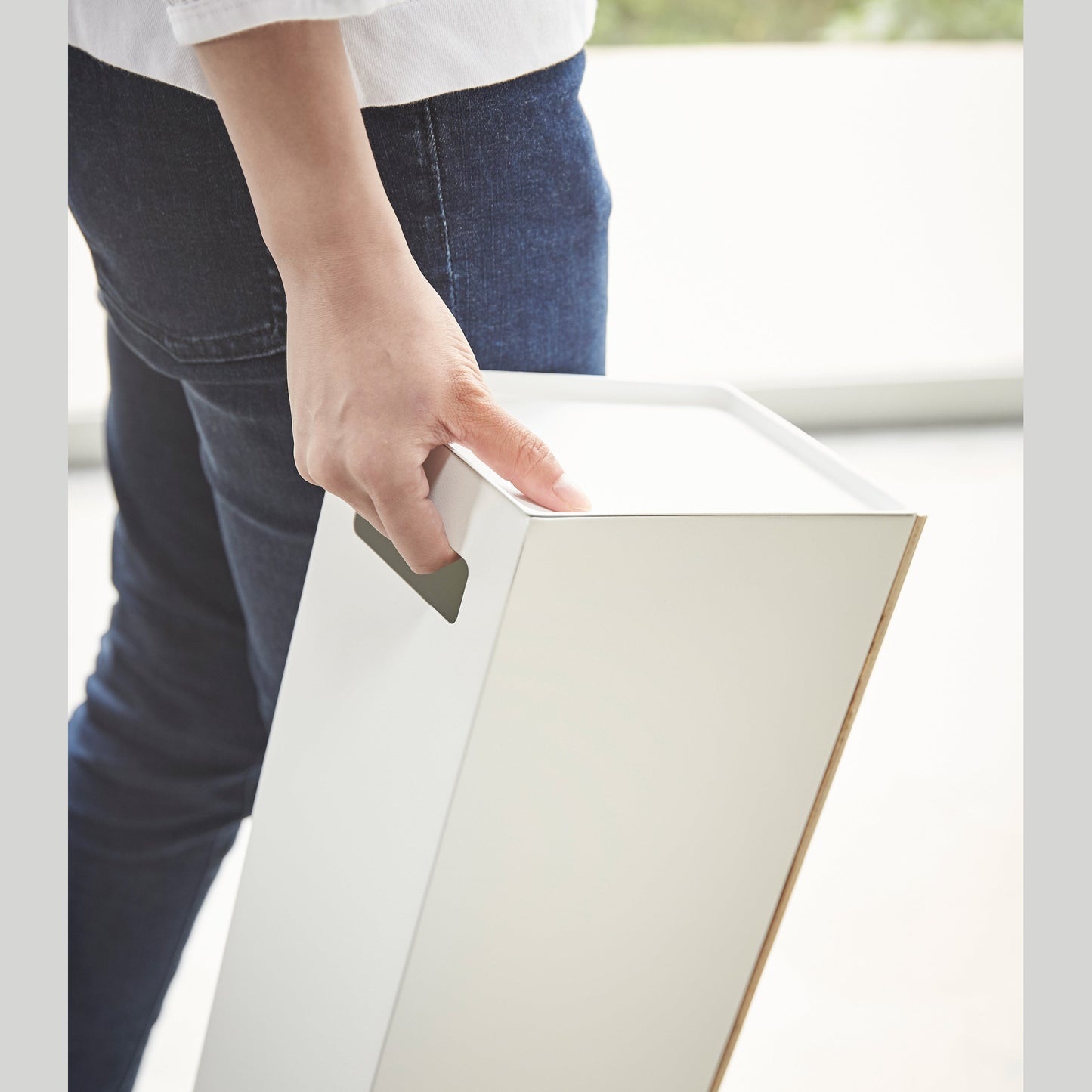 Side view of white Toilet Paper stocker carried by handle by Yamazaki home.