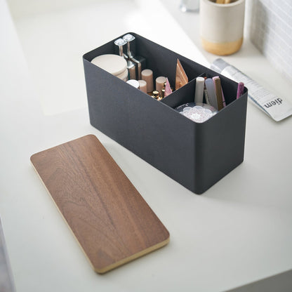 Black Countertop Organizer holding makeup products with cover off on sink countertop by Yamazaki Home.