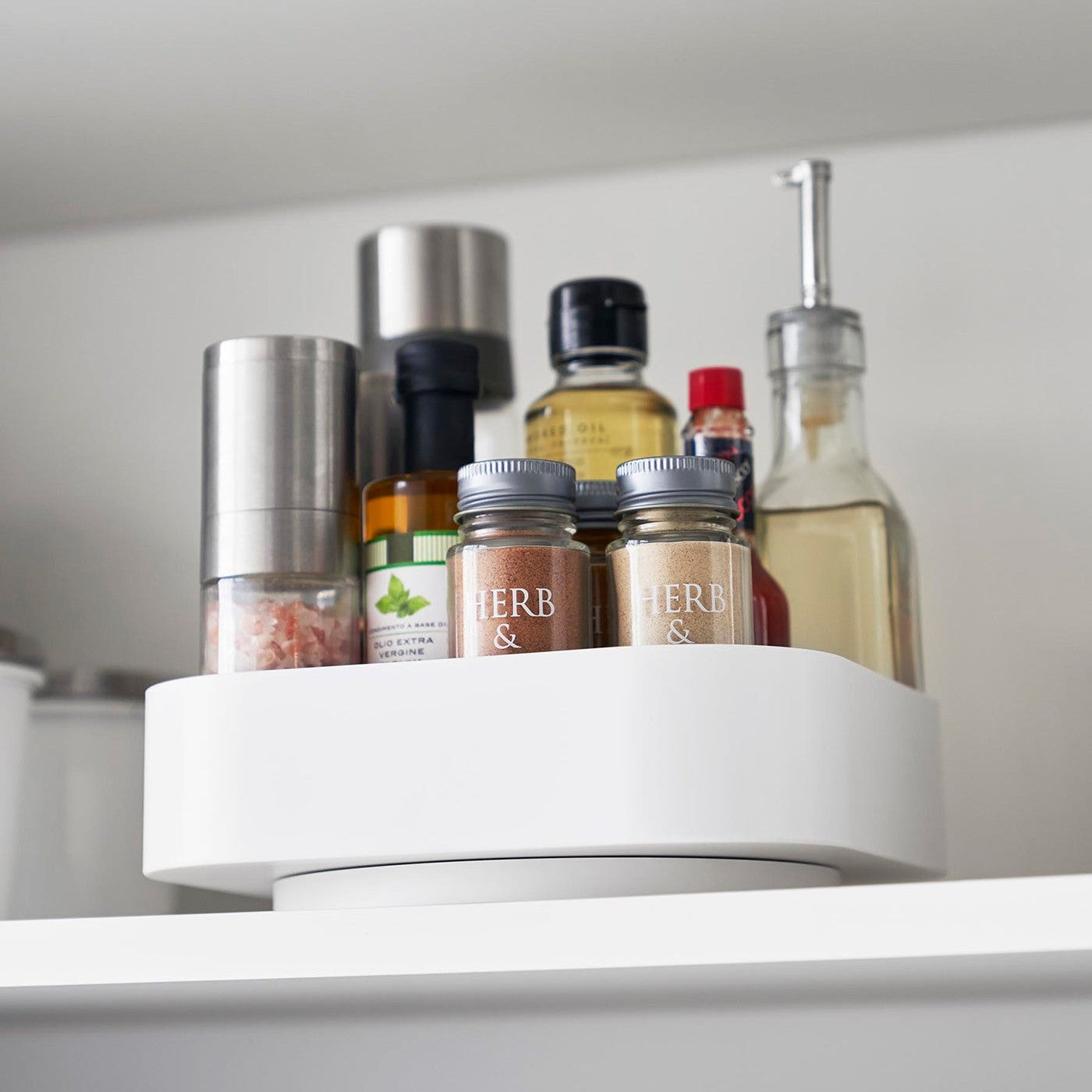 Close up of White Yamazaki Home Rotating Storage Tray with spices and oil stored