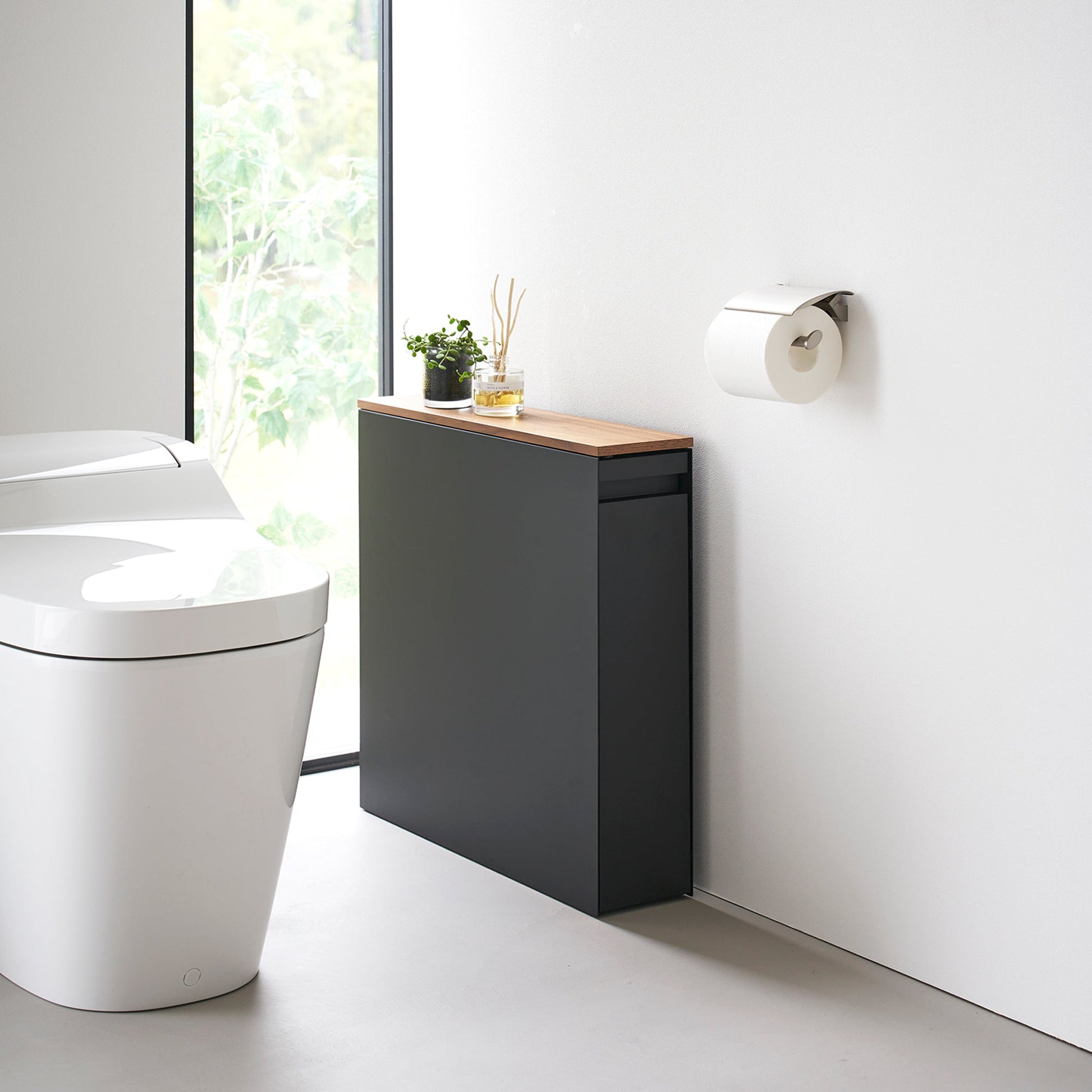 Black Yamazaki Home Pull-Out Bathroom Storage Cabinet next to a toilet in a bathroom