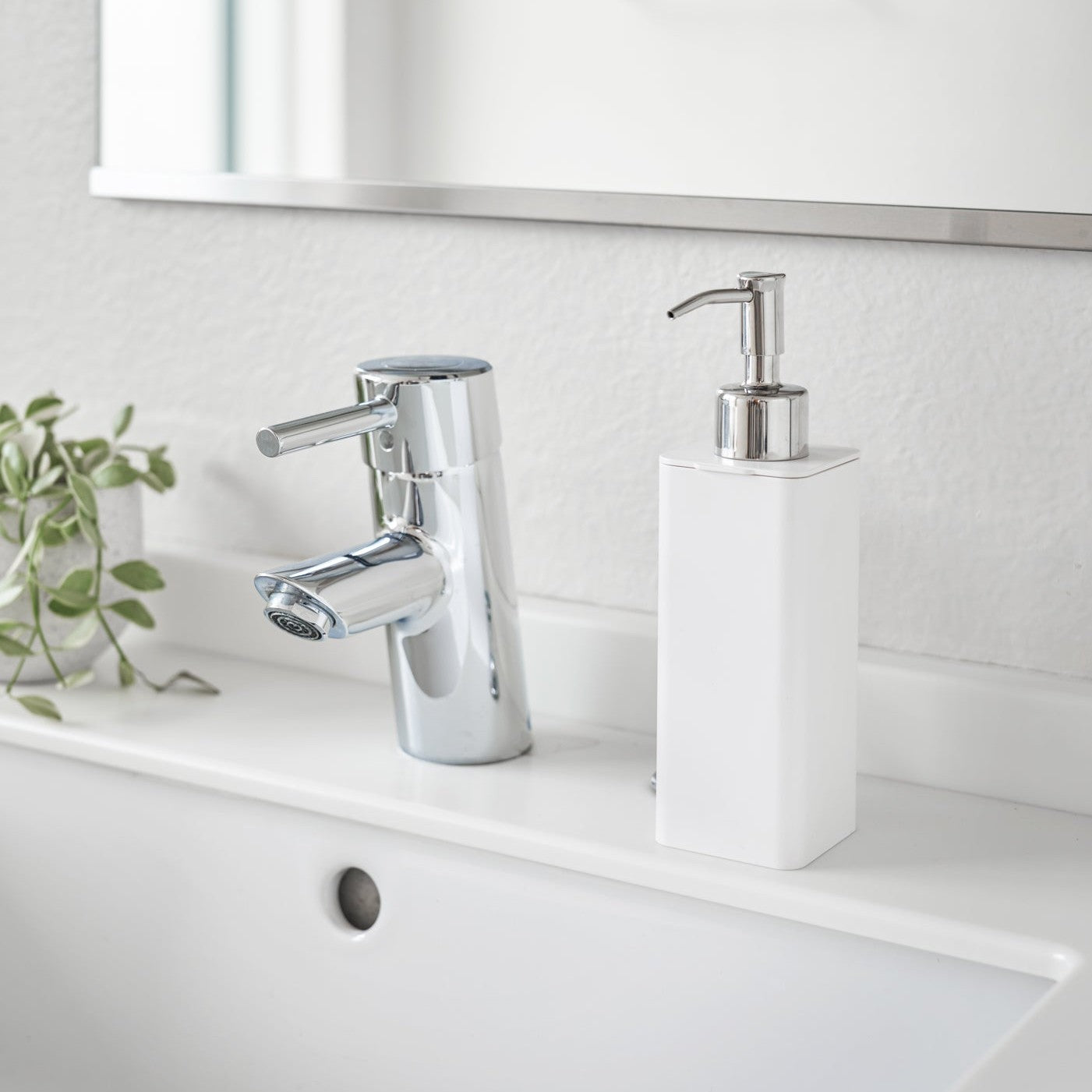White Hand Soap Dispenser on bathroom counter by Yamazaki Home.