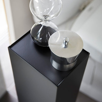Close up aerial view of Yamazaki Home black Toilet Organizer holding decor pieces.