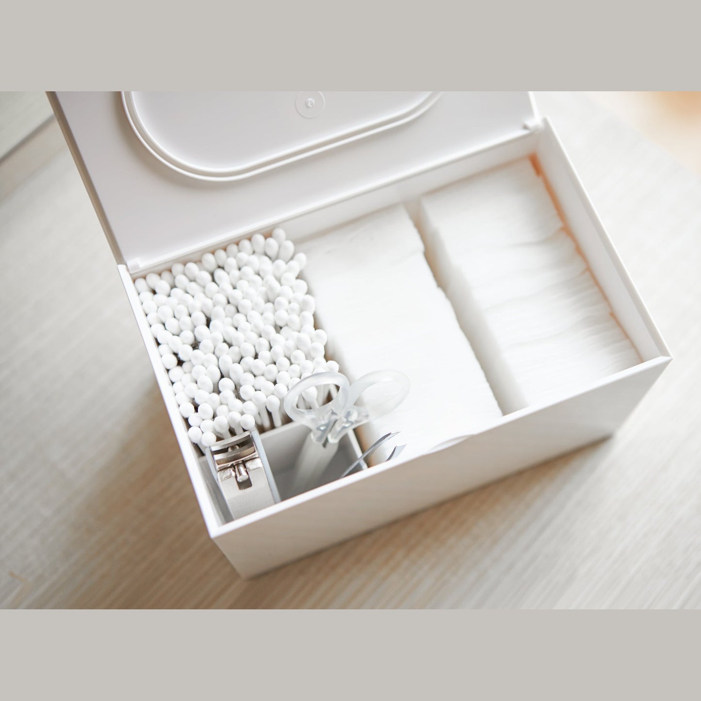 Aerial view of white Skincare Organizer holding cotton pads, cotton tips, and nail utensils by Yamazaki Home.