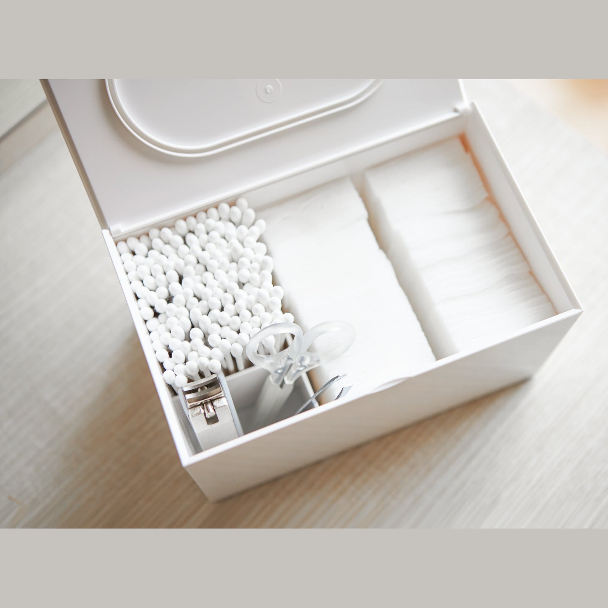 Aerial view of white Skincare Organizer holding cotton pads, cotton tips, and nail utensils by Yamazaki Home.