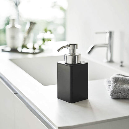 Black Foaming Soap Dispenser on bathroom sink counter by Yamazaki Home.