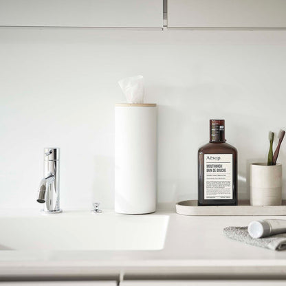 Large White Yamazaki Home Round Tissue Case on a bathroom sink counter