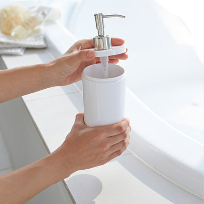 White Conditioner Dispenser with top off in bathroom by Yamazaki Home.