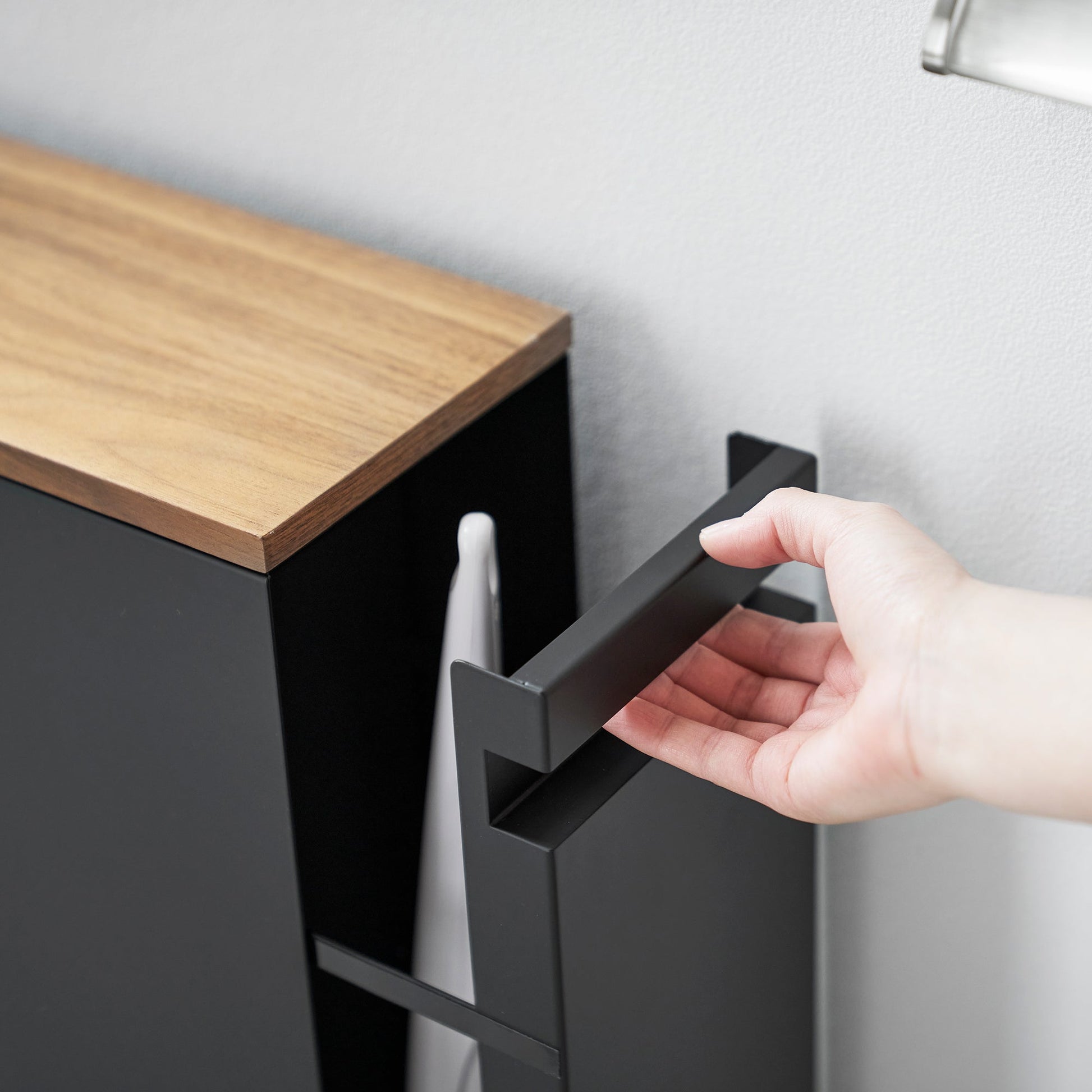 Close up of black Yamazaki Home Pull-Out Bathroom Storage Cabinet handle