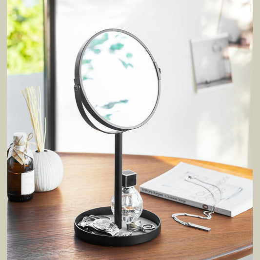 Black Vanity Mirror holding watch, rings, and perfume on table by Yamazaki Home.