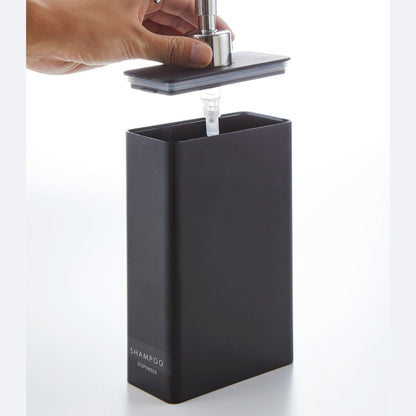 Black Shampoo Dispenser with top removed on white background by Yamazaki Home.