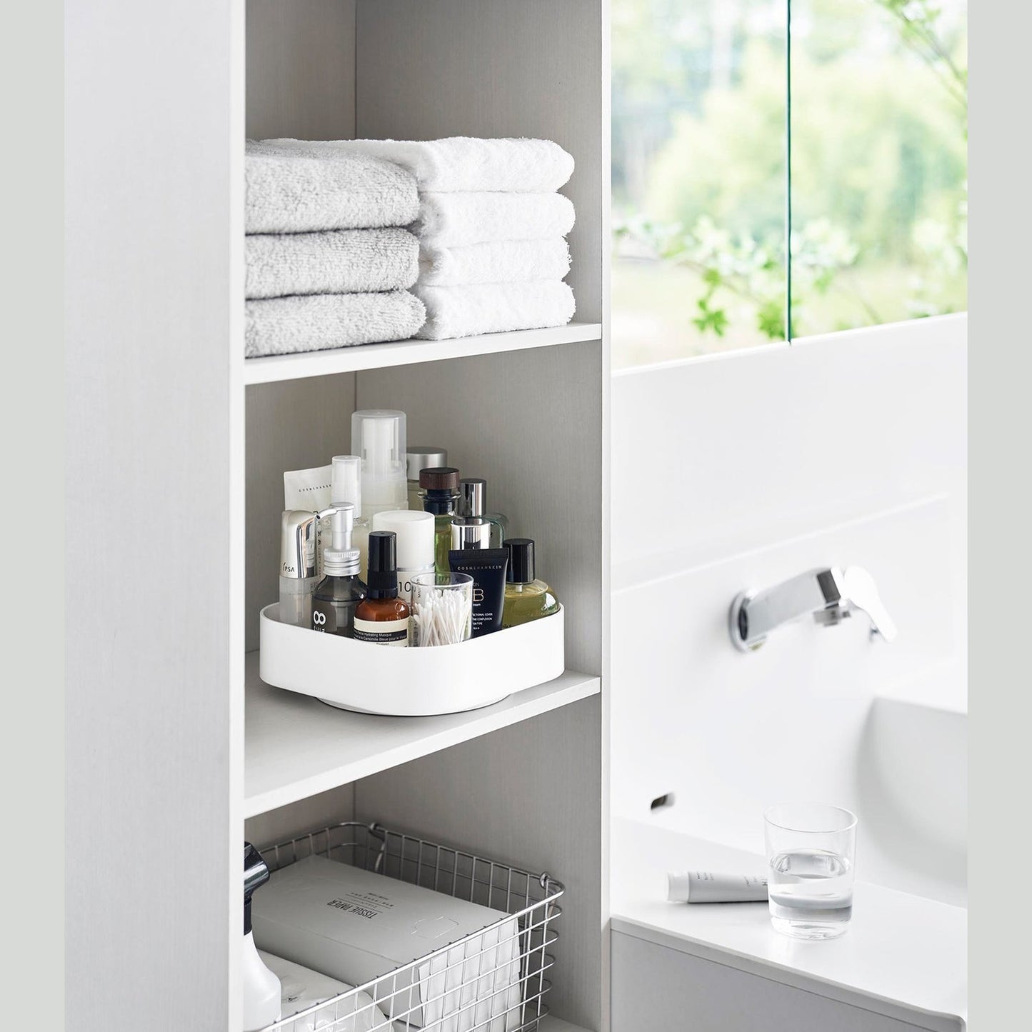 White Yamazaki Home Rotating Storage Tray with bathroom accessories stored