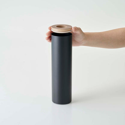 Top of small black Yamazaki Home Round Tissue Case being removed