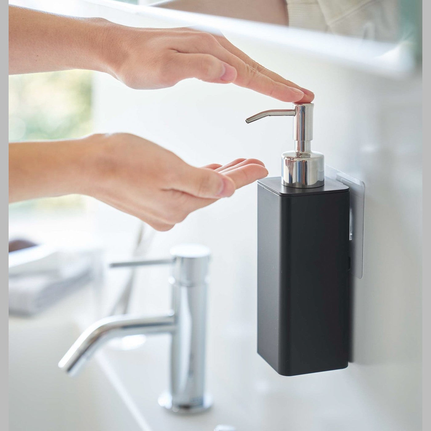 Dispensing soap from black Yamazaki Home square soap onto hands