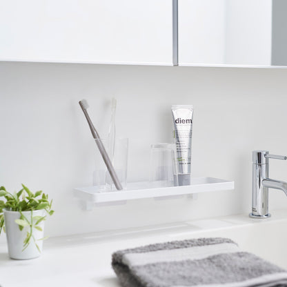 Yamazaki Home Traceless Adhesive Floating Tray attached to a bathroom wall