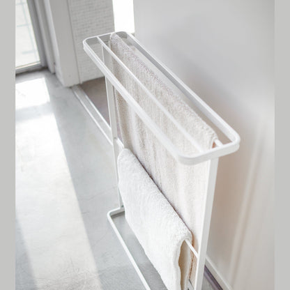 Aerial side view of white Bath Towel Hanger hodling towels by Yamazaki Home.