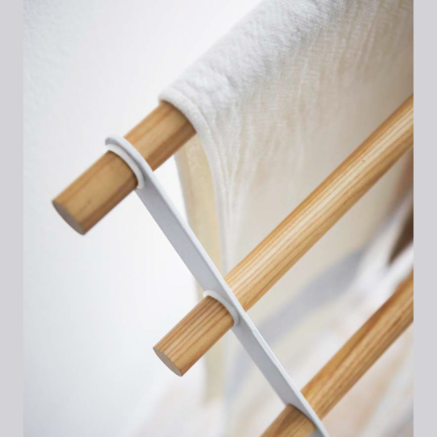 Aerial close up corner view of Bath Towel Rack holding towel on white background by Yamazaki Home.