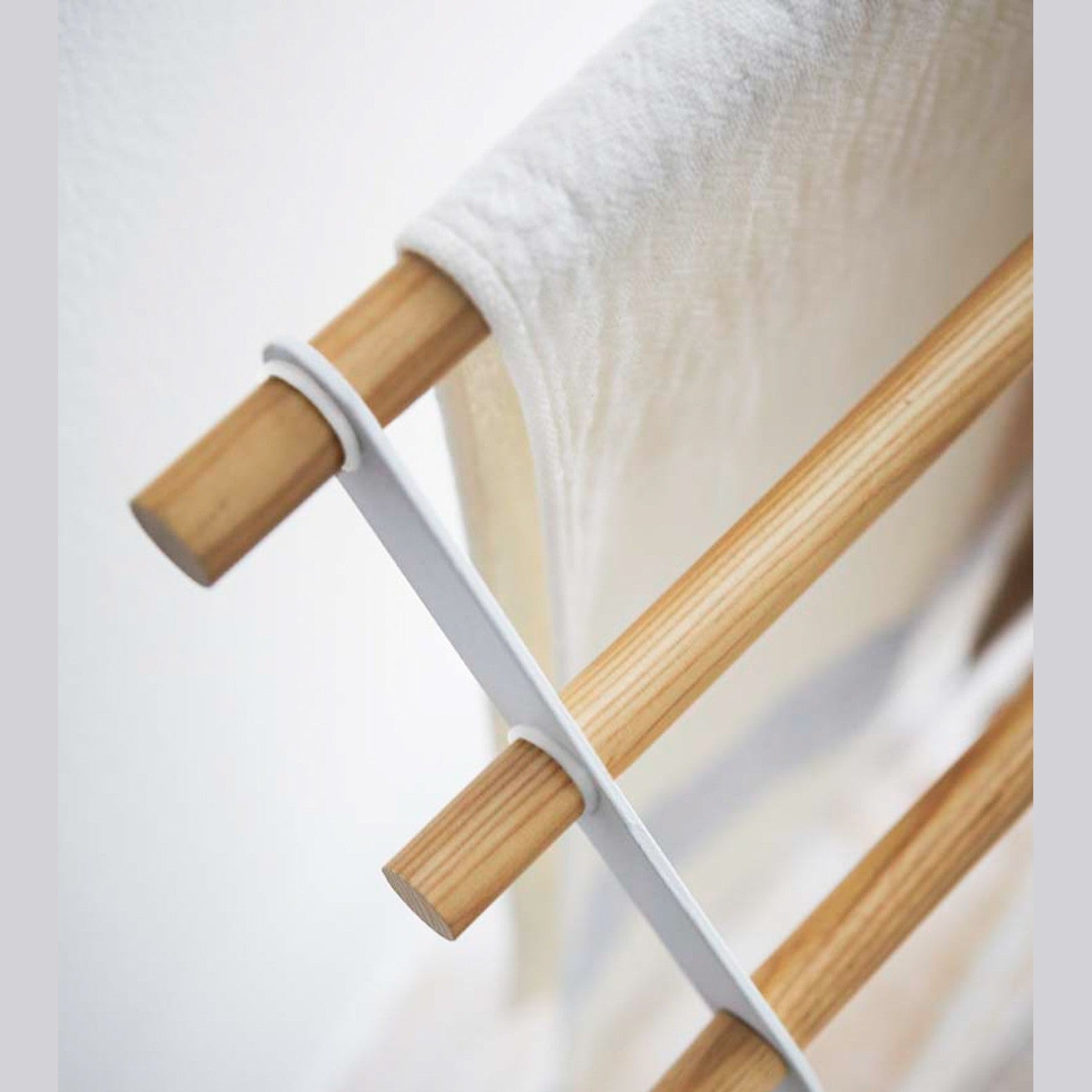 Aerial close up corner view of Bath Towel Rack holding towel on white background by Yamazaki Home.