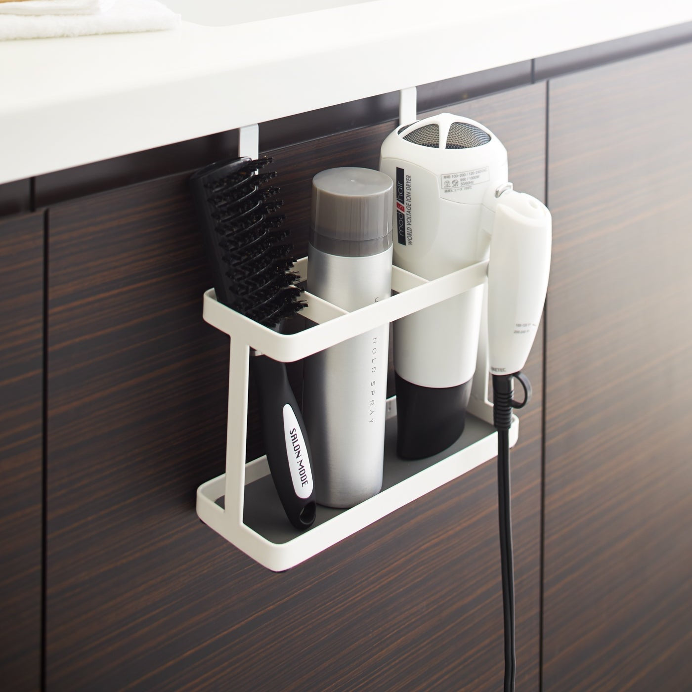 White Hair Tool and Styling Accessory Organizer holding hair products and tools in bathroom by Yamazaki Home.