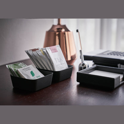 Side view of black Accessory Trays holding tea bags on desk by Yamazaki Home.