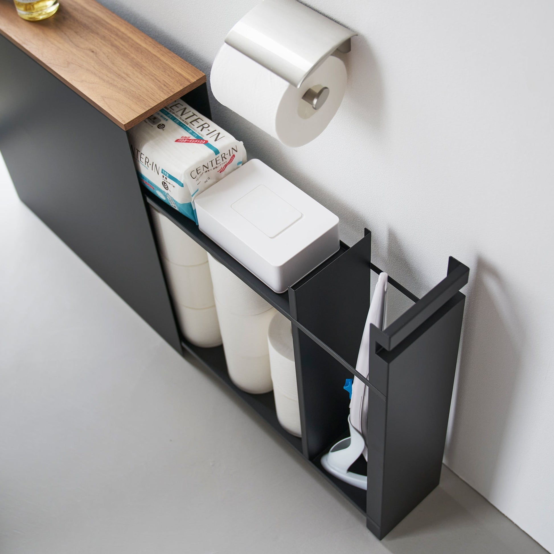Top-down view of black Yamazaki Home Pull-Out Bathroom Storage Cabinet partially open containing bathroom products