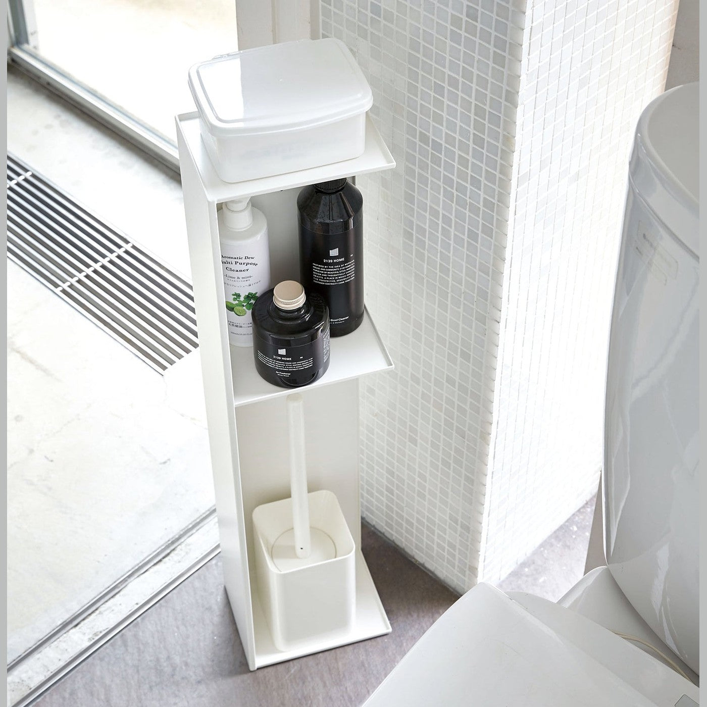 Yamazaki Home white Toilet Organizer holding wet wipe holder, cleaning products, and toilet brush in bathroom.