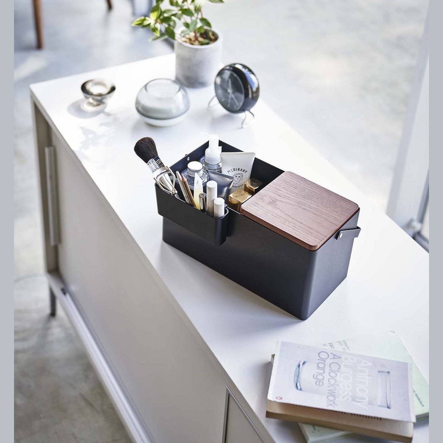 Closed black Makeup Organizer holding makeup products on table by Yamazaki Home.