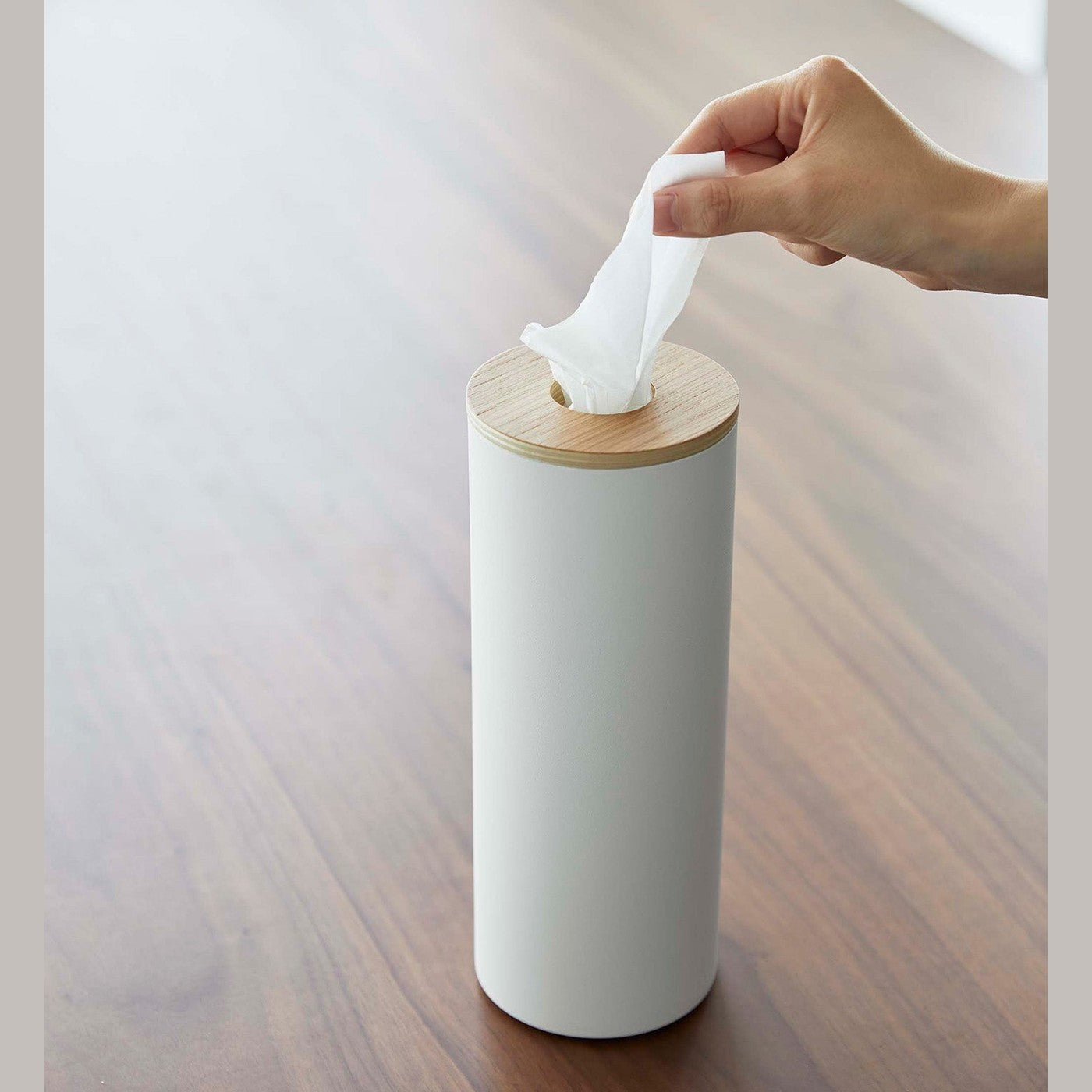 Large White Yamazaki Home Round Tissue Case and a tissue being pulled out