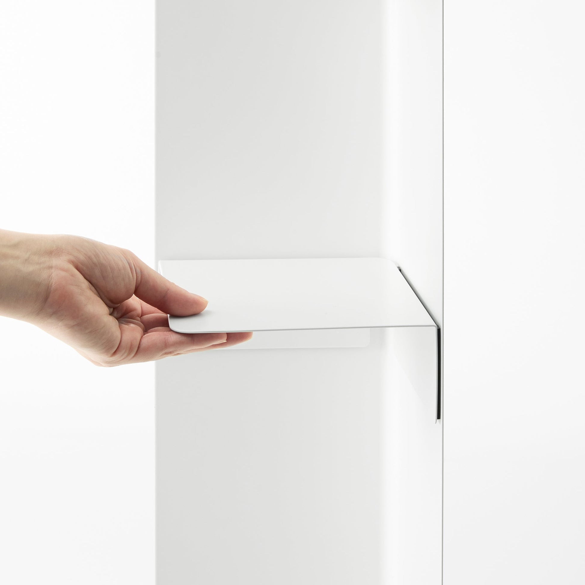 White Yamazaki Home Rolling Bathroom Organizer magnetic divider being attached to the inside of the base